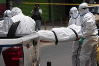 Nhân viên y tế xử lý xác một người chết trên đường tới bệnh viện ở El Salvador hôm 29/6. Ảnh: AFP.