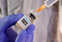 Một phụ nữ cầm lọ dán nhãn vaccine Covid-19 và ống tiêm trong hình ảnh minh hoạ được chụp hôm 10/4. Ảnh: Reuters.