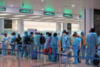 Hành khách trên chuyến bay quốc tế thương mại tới Việt Nam đầu tiên sau thời gian dài vì dịch COVID-19 làm thủ tục nhập cảnh tại sân bay Nội Bài. (Ảnh: CTV/Vietnam+).