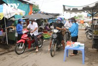 Do thân nhiệt và rửa tay sát khuẩn ở một khu vực chợ tại tỉnh Sóc Trăng.