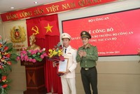 Thứ trưởng Lương Tam Quang trao quyết định và tặng hoa chúc mừng Đại tá Vũ Hoài Bắc.