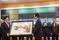 Bộ trưởng Bộ Tài chính Đinh Tiến Dũng nhận quà lưu niệm từ Thủ tướng Chính phủ nhân sự kiện Thủ tướng đến đánh cồng phiên giao dịch đầu Xuân Ất Mùi tại HNX, tháng 2/2015