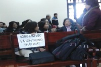 Cổ đông mang biểu ngữ trong một phiên tòa ở Hải Phòng năm 2014