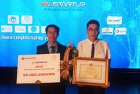 Phan Tấn Khải (trái) nhận giải thưởng trị giá 50 triệu đồng cho dự án nuôi cá tra bằng thảo dược. Ảnh: NVCC.