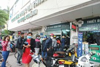 Người dân xếp hàng trước cửa nhà thuốc để chờ mua khẩu trang y tế, dung dịch sát khuẩn... Ảnh: Đức Thanh