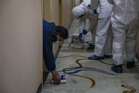 Nhân viên y tế tại một cơ sở cách ly ở Vũ Hán đặt phần ăn trưa trước cửa các phòng bệnh để hạn chế tiếp xúc với người nghi nhiễm virus corona. Ảnh: AFP.