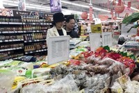 Khách lựa chọn hàng hóa tại siêu thị Vinmart. Ảnh: Trần Việt - TTXVN 