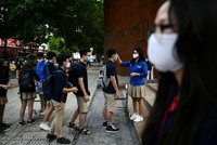 Kiểm tra thân nhiệt đối với học sinh tại các trường học ở Hà Nội. Ảnh: AFP