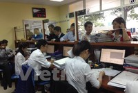 Người dân đi làm thủ tục cấp sổ đỏ tại Văn phòng đăng ký đất đai. (Ảnh: H.T/Vietnam+)