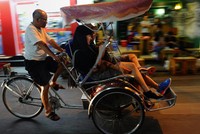 Du khách quốc tế ngồi xích lô tham quan phố cổ Hà Nội. (Ảnh: AFP)
