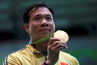 Xạ thủ Hoàng Xuân Vinh và chiếc HC Vàng Olympic môn bắn súng. Ảnh: Reuters.