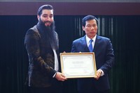 Bộ trưởng Văn hóa Thể thao và Du lịch trao giấy chứng nhận Đại sứ Du lịch Việt Nam cho ông Jordan Vogt-Roberts. Ảnh: Giang Huy.