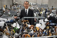 Ông Shoji Okubo, giám đốc trung tâm xử lý đồ thất lạc của Sở cảnh sát Tokyo, đứng giữa những chiếc ô vô chủ. Ảnh: Japan Times 