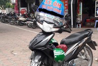 Biển hiệu xe ôm, số điện thoại riêng và hai chiếc mũ Grab để dễ mời khách. Ảnh: Hiếu Công .