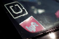 Logo của Uber và Lyft trên một xe hơi tại Mỹ. Ảnh: Reuters.
