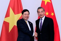 Ngoại trưởng Trung Quốc Vương Nghị, phải, và Phó thủ tướng Việt Nam Phạm Bình Minh trong cuộc gặp ngày 16/12 tại Lào. Ảnh: TTXVN.