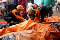 Lực lượng cứu hộ Indonesia bên cạnh túi đựng thi thể nạn nhân sáng 24/12. Ảnh: AFP.