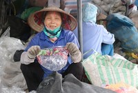 Bà Nguyễn Thị Hồng Thắm cầm một vỏ túi kẹo có xuất xứ từ Mỹ. Ảnh: Guardian.