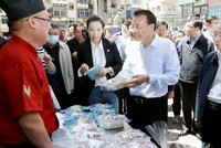 Thủ tướng Lý Khắc Cường ghé thăm một quầy bán hàng rong. (Ảnh: THX).