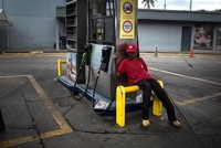 Một nhân viên ngồi thất thần tại trạm xăng Petroleos de Venezuela tại Caracas, Venezuela. (Nguồn: Wil Riera | Bloomberg | Getty Images)