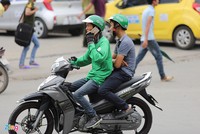 Khách hàng phải trả thêm phụ phí khi đi GrabBike dịp Tết Nguyên đán mỗi chuyến ở mức 10.000-20.000 đồng. Ảnh: Việt Hùng.