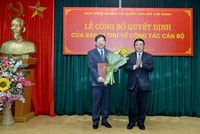 GS.TS. Nguyễn Xuân Thắng (phải) trao quyết định và tặng hoa chúc mừng đồng chí Nguyễn Duy Bắc