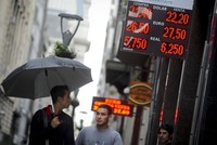 Người dân đi qua một quầy đổi tiền ở thủ đô Buenos Aires. Ảnh: AP.