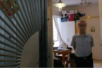 Ông chủ nhà Ng Goon-lau, 66 tuổi, đứng trong căn hộ của mình, nơi từng xảy ra hai vụ tự tử, một người đàn ông tự tử bằng than, một nữ cảnh sát treo cổ. Ảnh: Reuters.