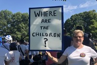 Một phụ nữ tham gia cuộc biểu tình ngày 30/6 ở Washington giơ cao tấm biển với dòng chữ ghi "Những đứa trẻ ở đâu?". Ảnh: CNN.