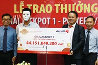 Khách hàng đeo mặt nạ che mặt khi nhận giải thưởng hơn 44 tỷ đồng. Ảnh: Xuân Ngọc.