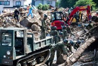 Lực lượng cứu hộ và binh sĩ dọn dẹp đống đổ nát trên một con phố sau trận lụt ở Kumano, tỉnh Hiroshima, ngày 9/7. Ảnh: AFP.