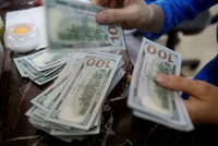 Một nhân viên ngân hàng đếm tiền USD tại Hà Nội. Ảnh: Reuters.