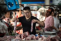 Một người bán thịt lợn tại chợ ở Chu Gia Giác. Ảnh: Washington Post.