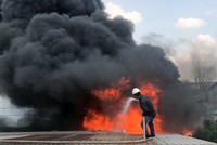 Công nhân cố dập lửa trong đám cháy. Ảnh: Tin Tin.