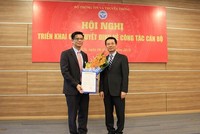 Quyền Bộ trưởng Bộ TT&TT Nguyễn Mạnh Hùng trao quyết định và chúc mừng ông Lê Văn Tuấn. Ảnh Infonet.vn