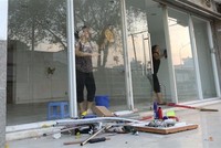 Cư dân block A, chung cư Carina Plaza trở về thu dọn để mở cửa lại quán cà phê Yuki ở tầng 1. (Ảnh: Thanh Vũ/TTXVN).