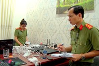 Công an kiểm đếm thiết bị điện tử tại nơi nhóm người Trung Quốc thuê để làm thẻ ATM giả và đánh bạc. Ảnh: Quang Bình. 