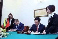 Phó Thủ tướng Phạm Bình Minh và Bộ trưởng Nội vụ Litva Eimutis Misiunas ký Hiệp định miễn thị thực cho người mang hộ chiếu ngoại giao và công vụ giữa hai nước. Ảnh: VGP/Hải Minh.