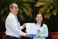 Ủy viên Bộ Chính trị, Bí thư Thành ủy TPHCM Nguyễn Thiện Nhân trao Nghị quyết của UBTVQH cho đồng chí Nguyễn Thị Lệ.