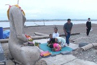 Du khách và người dân tới hành lễ trước một pho tượng Phật cao chừng 4m của ngôi đền cũ.