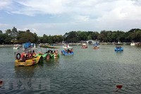 Bơi thuyền bên hồ tại công viên Văn hóa Đầm Sen. (Ảnh: Thanh Vũ/TTXVN).