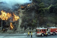 Nhân viên cứu hỏa nỗ lực khống chế các đám cháy rừng lan rộng tại Newhall, California, Mỹ, ngày 11/10. Ảnh: AFP/TTXVN.