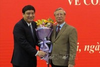 Đồng chí Trần Quốc Vượng chúc mừng đồng chí Nguyễn Đắc Vinh. Ảnh TTXVN.