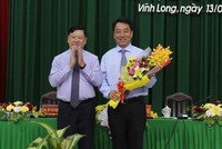 Ông Trần Văn Rón, Ủy viên Trung ương Đảng, Bí thư Tỉnh ủy Vĩnh Long (bên trái) tặng hoa chúc mừng tân Chủ tịch UBND tỉnh Vĩnh Long Lữ Quang Ngời.