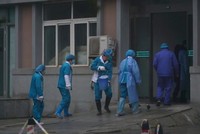 Các nhân viên y tế tẩy rửa lối vào một trung tâm y tế ở Vũ Hán ngày 22/1. (Ảnh: AP).