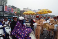 Hình ảnh lực lượng CSGT Hà Nội phát khẩu trang miễn phí cho người tham gia giao thông tại nút giao Xã Đàn - Ô Chợ Dừa.