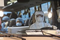 Xe đưa công nhân Việt Nam rời Sân bay Vân Đồn đến khu vực cách ly để điều trị. (Ảnh: Dương Giang/TTXVN).