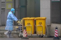 Công nhân thu gom rác thải y tế tại một trung tâm điều trị bệnh nhân nhiễm Covid-19 ở Vũ Hán hôm 22/1. Ảnh: 
AP.
