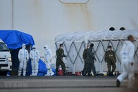 Nhân viên y tế làm nhiệm vụ gần du thuyền Diamond Princess bị cách ly tại cảng Yokohama, Nhật Bản ngày 13/2. (Ảnh: AFP/TTXVN).