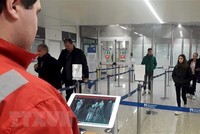 Nhân viên chữ thập đỏ dùng máy quét thân nhiệt để kiểm tra thân nhiệt hành khách tại sân bay Fiumicino, Rome, Italy, ngày 5/2/2020. (Ảnh: AFP/ TTXVN).